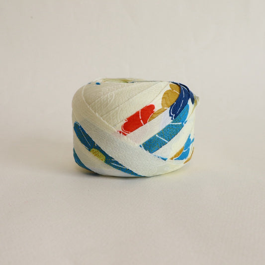 薄い卵色に赤・緑・青・黄の花柄・化繊(Y02601004）